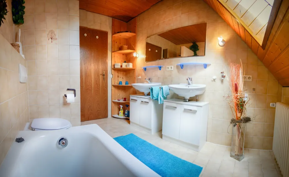 Geräumiges Badezimmer mit Badewanne und zwei Waschbecken