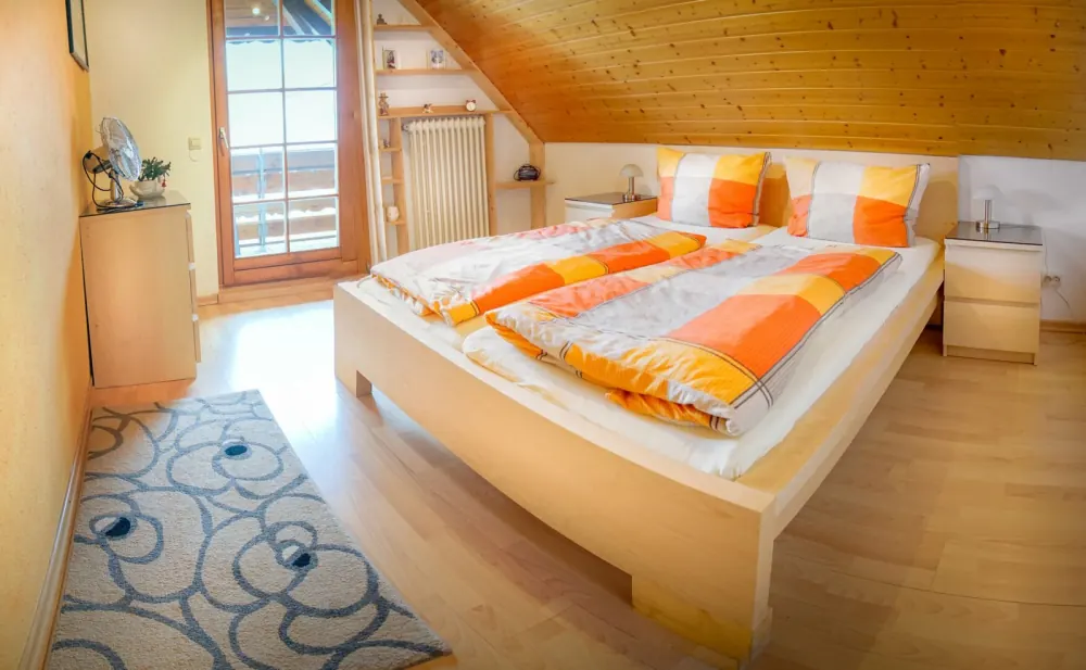 Schlafzimmer mit Doppelbett unter der Dachschräge